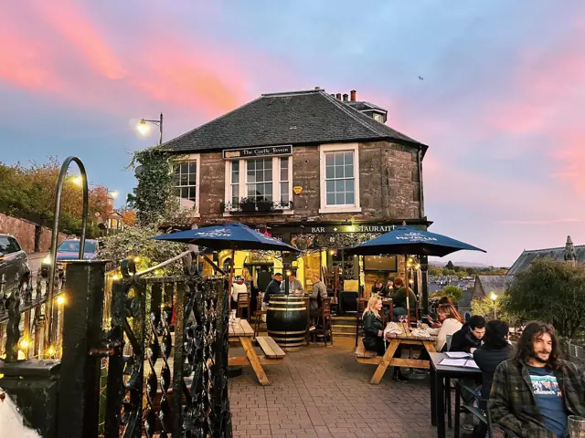 The Castle Tavern exterior with outdoor seating at sunset
